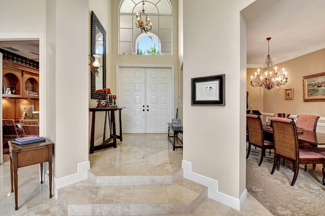 entrance foyer with crown molding, an inviting chandelier, and a high ceiling