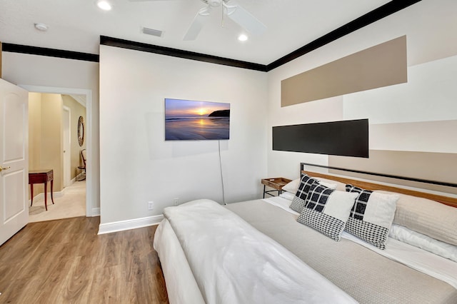 bedroom with hardwood / wood-style floors, crown molding, and ceiling fan