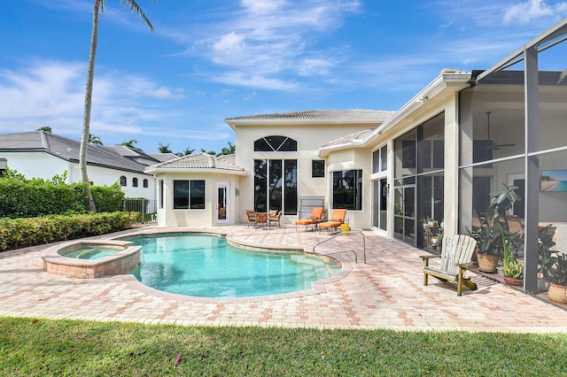 view of pool featuring an in ground hot tub, a patio area, and glass enclosure