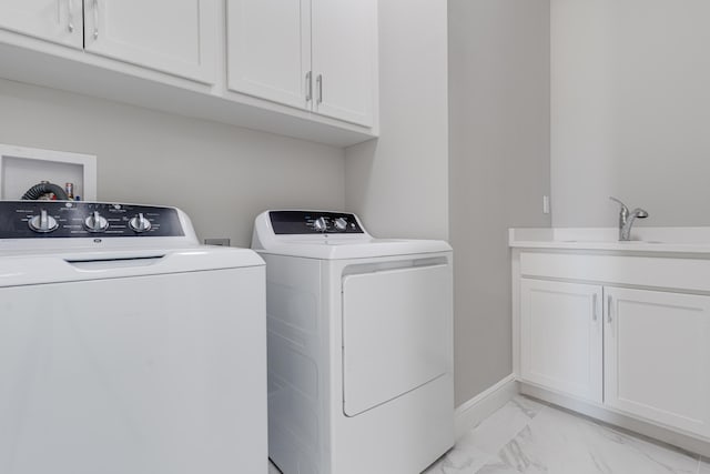 clothes washing area with cabinets, independent washer and dryer, and sink