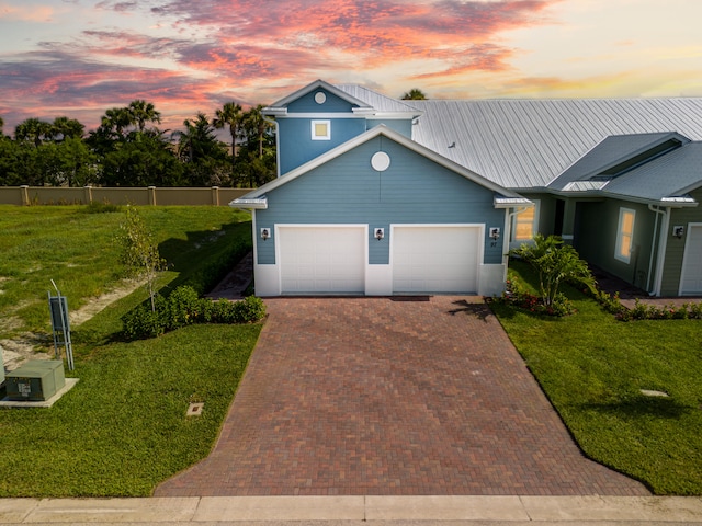 view of front of house with a garage and a lawn