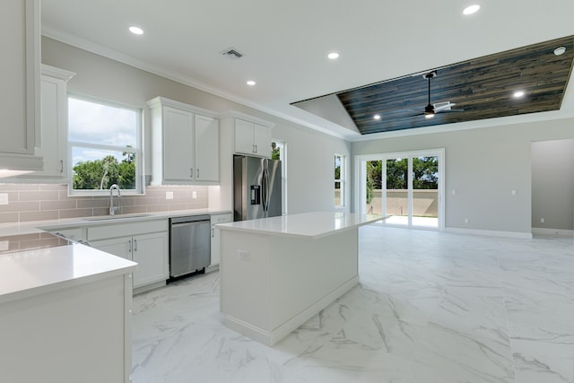 kitchen with white cabinetry, backsplash, appliances with stainless steel finishes, and a kitchen island