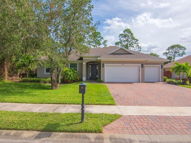 ranch-style house featuring a garage and a front lawn