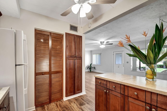 kitchen featuring ceiling fan, a wealth of natural light, light wood-type flooring, and white fridge