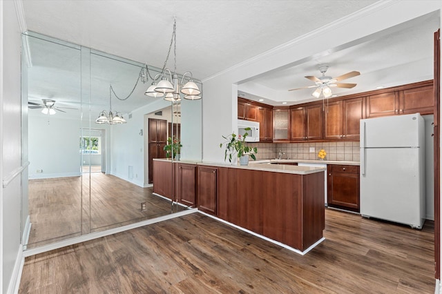 kitchen featuring hanging light fixtures, dark hardwood / wood-style flooring, white appliances, ceiling fan, and decorative backsplash