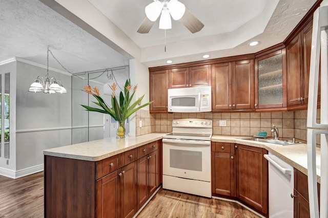 kitchen featuring sink, decorative light fixtures, white appliances, light hardwood / wood-style floors, and crown molding