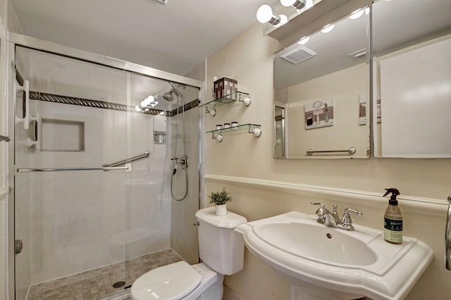 bathroom featuring sink, tile patterned flooring, a shower with shower door, and toilet