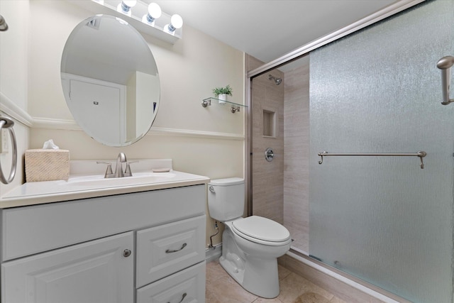 bathroom with tile patterned floors, toilet, vanity, and walk in shower