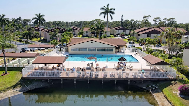 rear view of property with a patio, a water view, and a community pool