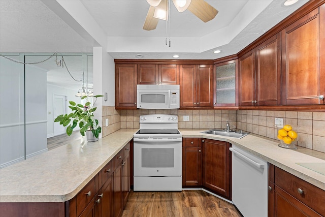 kitchen with white appliances, sink, dark wood-type flooring, and decorative backsplash