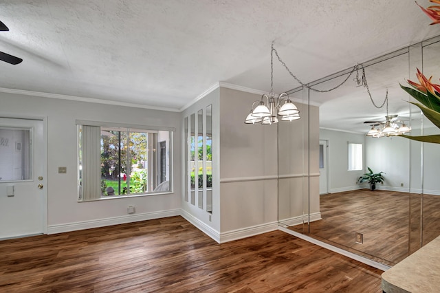 unfurnished dining area with ceiling fan with notable chandelier, ornamental molding, and dark hardwood / wood-style flooring