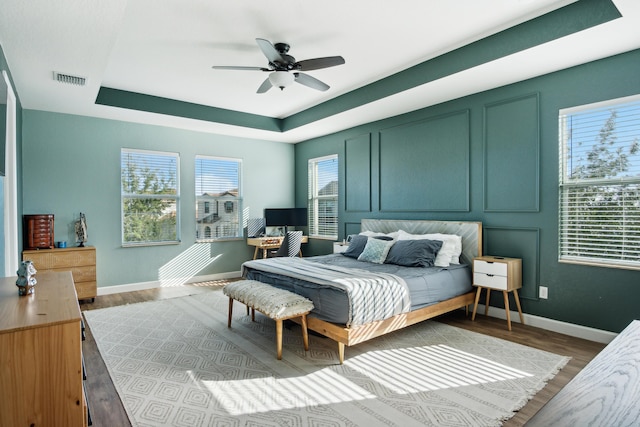 19535 Split Rail Run, Loxahatchee, FL 33470 - bedroom with a tray ceiling, baseboards, wood finished floors, and a ceiling fan