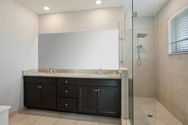 bathroom featuring vanity, tile patterned floors, and tiled shower