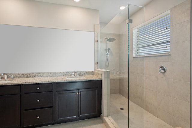 bathroom featuring vanity, tile patterned floors, and a tile shower