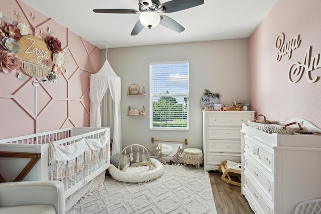 19535 Split Rail Run, Loxahatchee, FL 33470 - bedroom featuring dark wood finished floors, a crib, and a ceiling fan