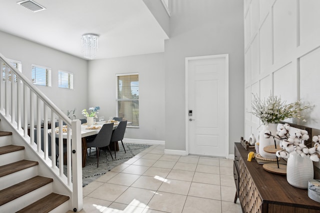 tiled foyer with a notable chandelier