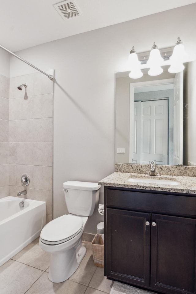 full bathroom featuring tile patterned floors, vanity, tiled shower / bath combo, and toilet