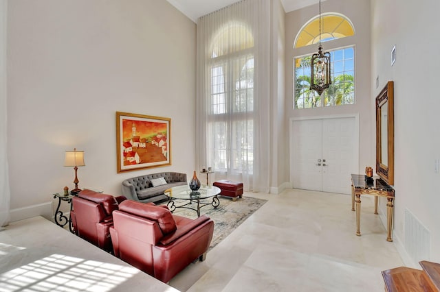 living room with a towering ceiling and a chandelier