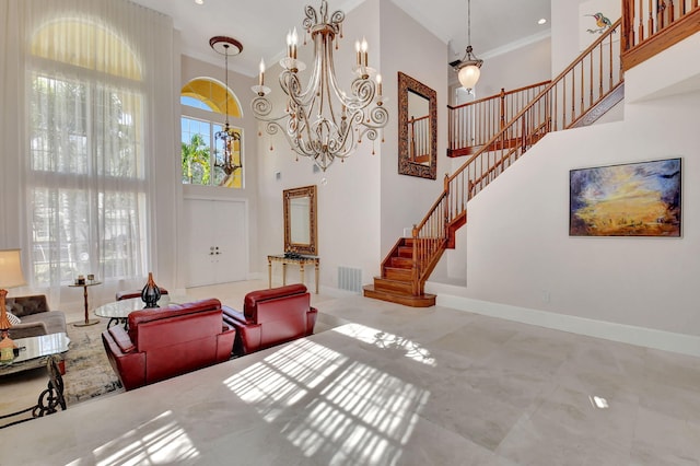 living room with a towering ceiling, ornamental molding, and a chandelier