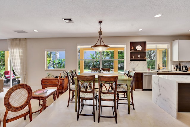 dining room with a textured ceiling and sink