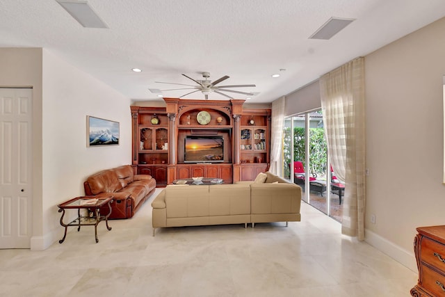 living room with a textured ceiling and ceiling fan