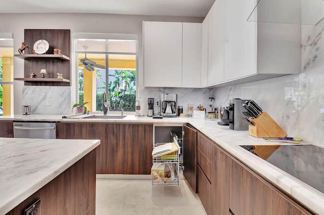 kitchen with sink, dishwasher, white cabinetry, and decorative backsplash