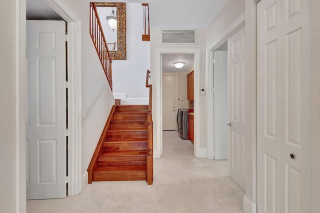 stairway featuring washing machine and dryer