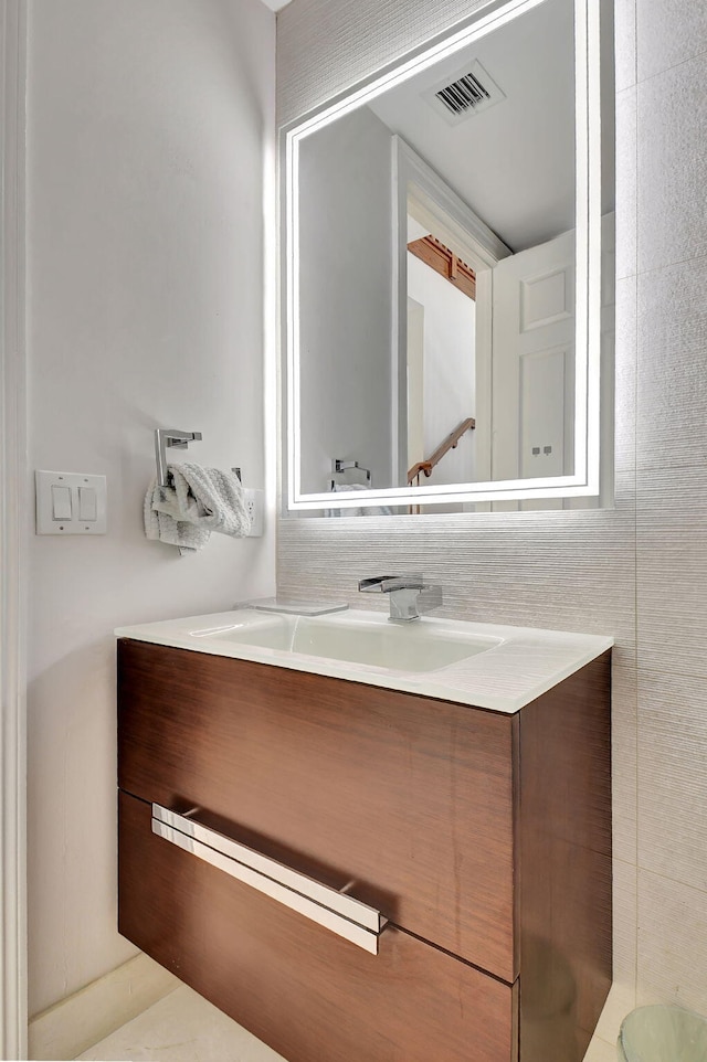 bathroom featuring vanity and tile walls