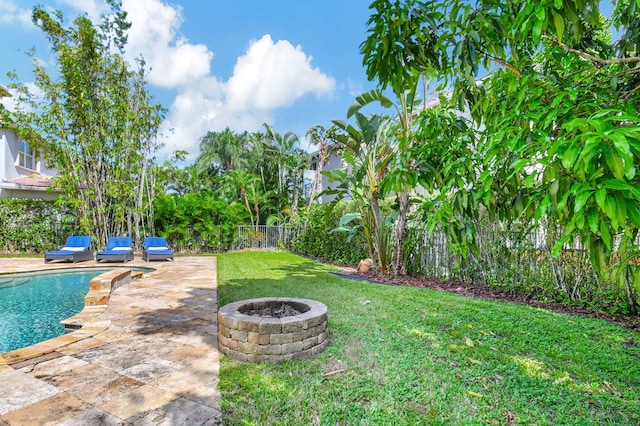 view of yard featuring a fenced in pool, a patio area, and a fire pit