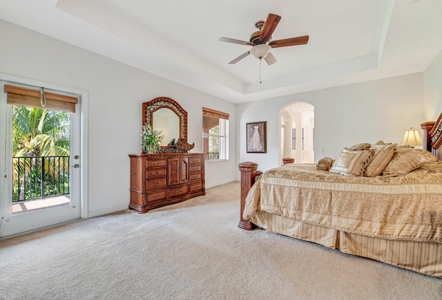 bedroom with carpet flooring, ceiling fan, a raised ceiling, and access to outside