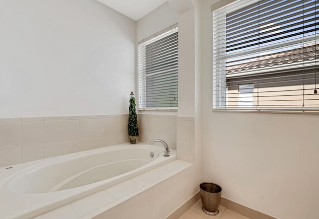 bathroom featuring tile patterned floors, tiled tub, and a wealth of natural light