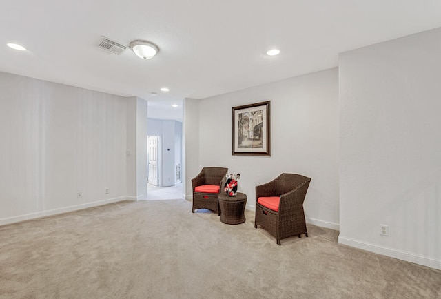 living area featuring light carpet