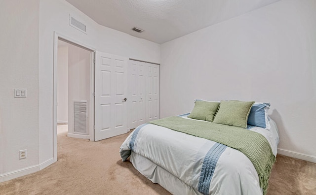 bedroom featuring carpet, a textured ceiling, and a closet