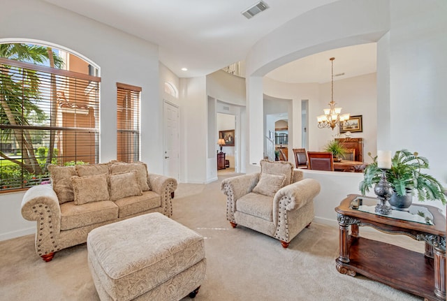 carpeted living room featuring a chandelier