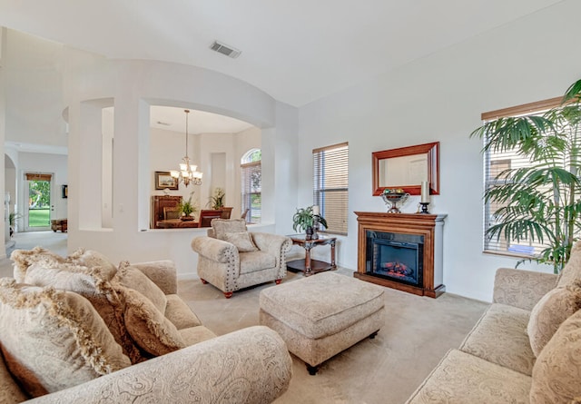 carpeted living room featuring a chandelier