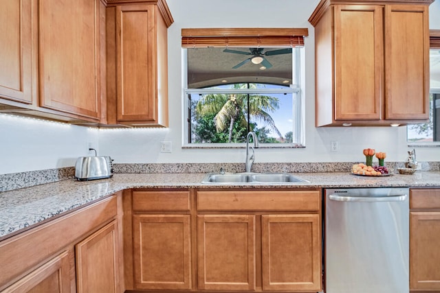 kitchen with dishwasher, light stone counters, and sink