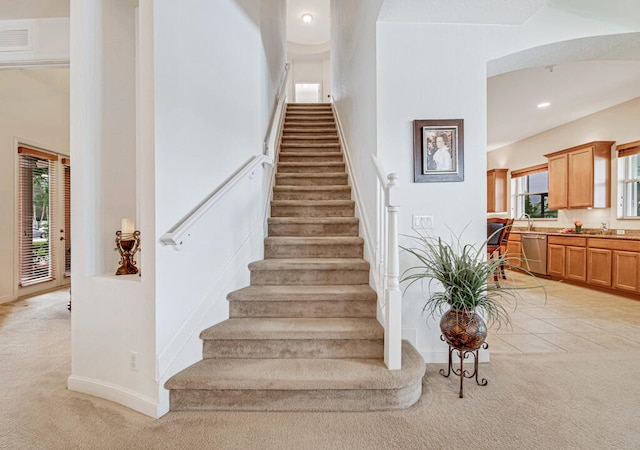 stairs with carpet flooring and sink