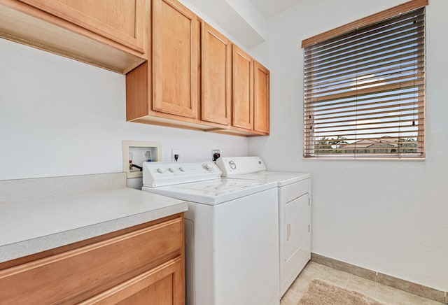 clothes washing area featuring light tile patterned floors, cabinets, and independent washer and dryer