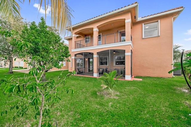 rear view of property with a balcony, a yard, and a patio