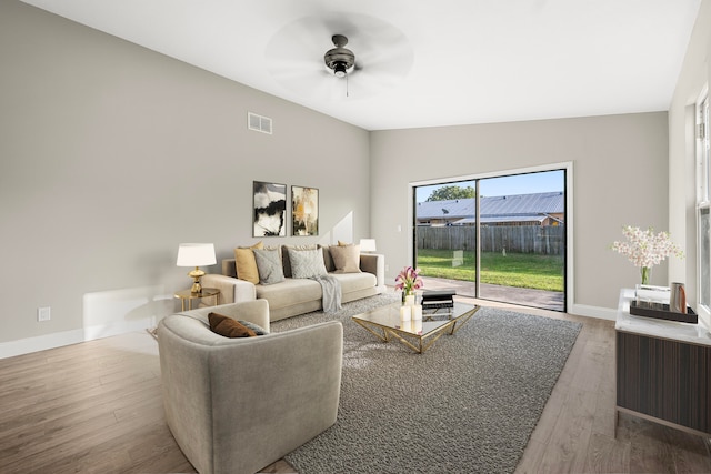 living room with ceiling fan, lofted ceiling, and hardwood / wood-style flooring