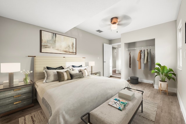 bedroom with a closet, hardwood / wood-style flooring, and ceiling fan