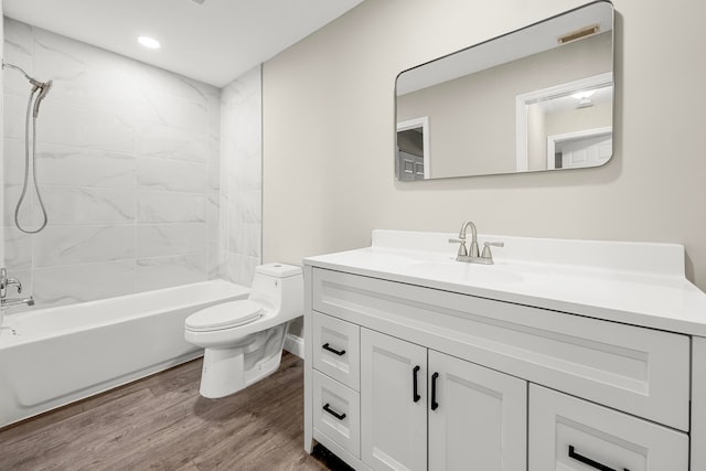 full bathroom featuring hardwood / wood-style floors, toilet, vanity, and tiled shower / bath combo