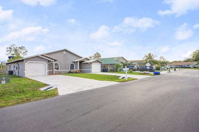 ranch-style house with a garage, a front lawn, and central air condition unit