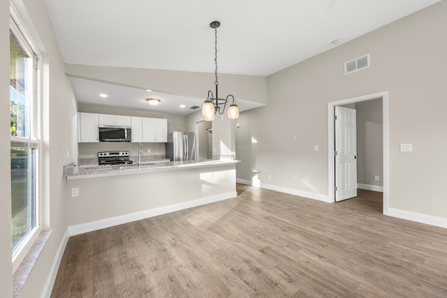 kitchen featuring decorative light fixtures, lofted ceiling, kitchen peninsula, white cabinetry, and appliances with stainless steel finishes