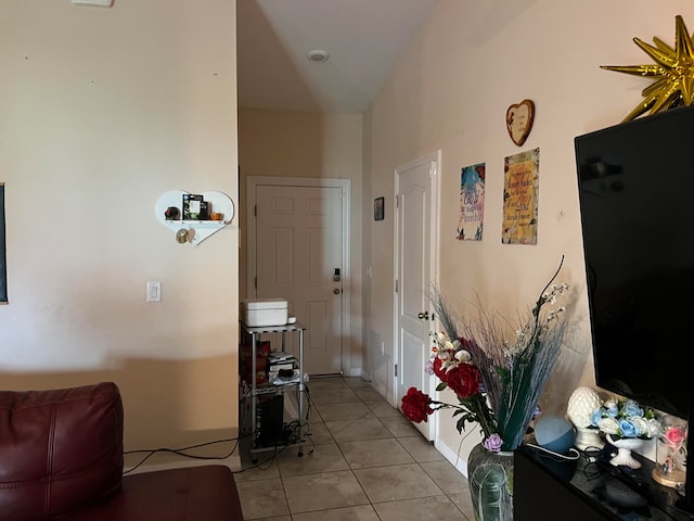 hall with vaulted ceiling and light tile patterned floors