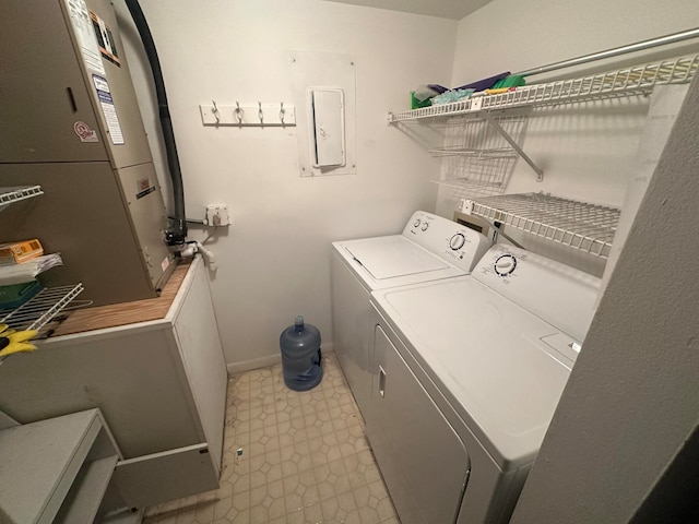 clothes washing area with electric panel, separate washer and dryer, and heating unit