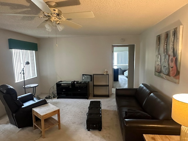 carpeted living room with ceiling fan and a textured ceiling