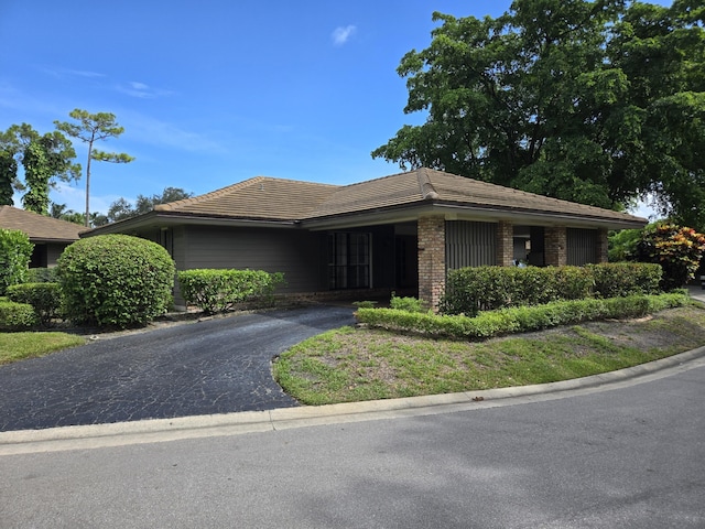 600 Cypress Key Dr, Atlantis, FL 33462 - ranch-style home with driveway, brick siding, and a tiled roof