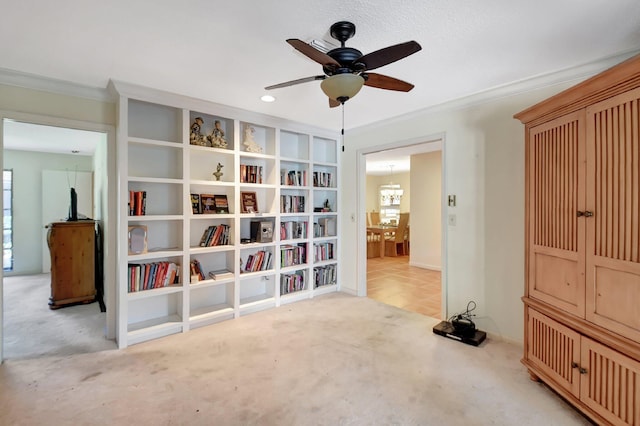 living area featuring ceiling fan with notable chandelier, light colored carpet, and ornamental molding