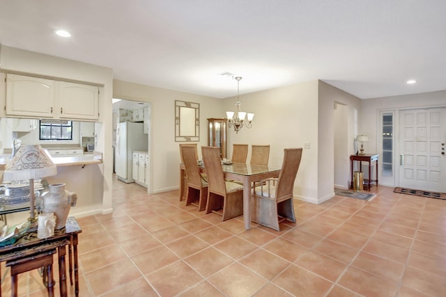 dining space with light tile patterned floors and an inviting chandelier